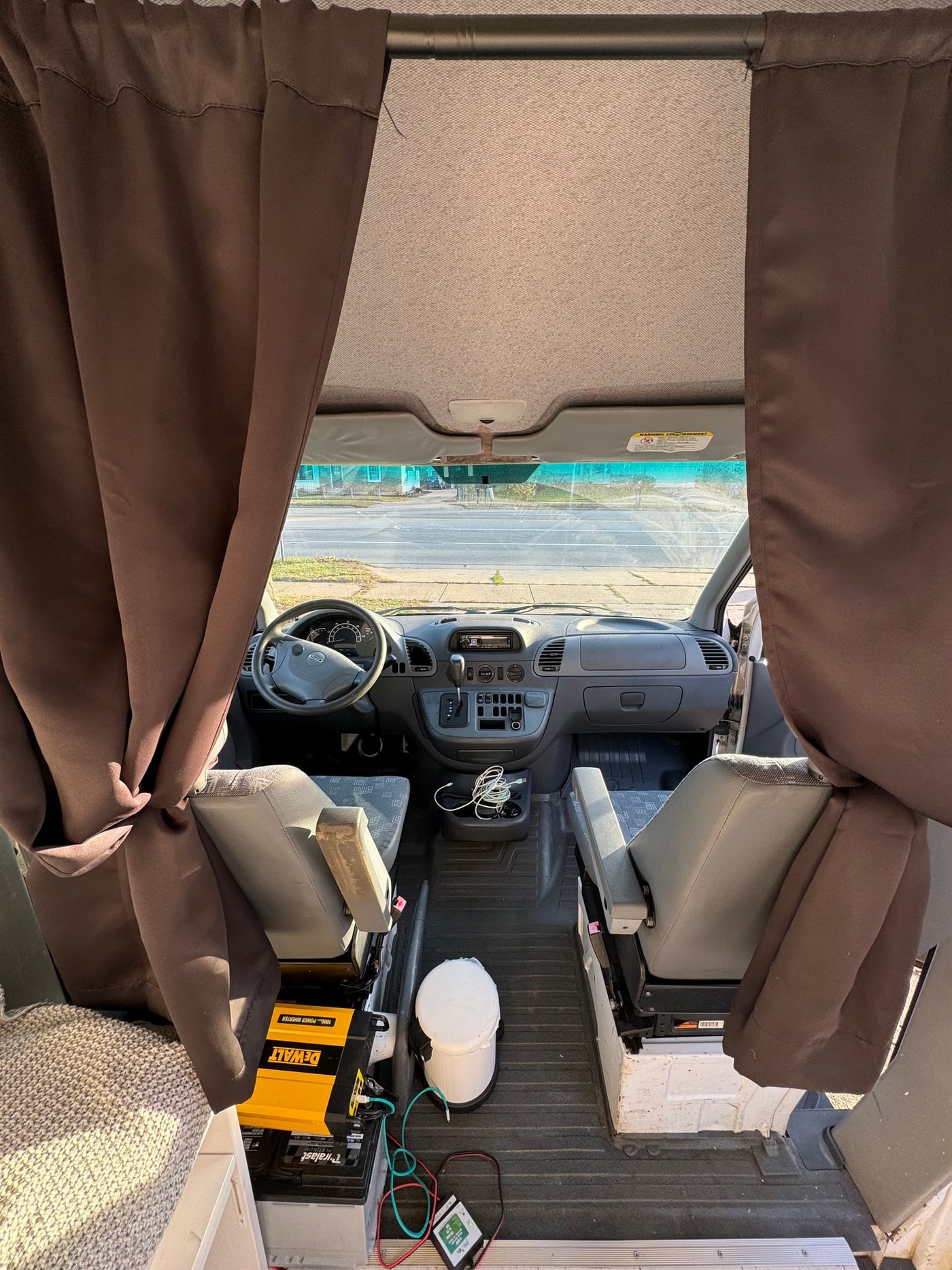is parked on a sunlit driveway with autumn foliage.|Modern RV rental interior with a comfy bed — photo 3