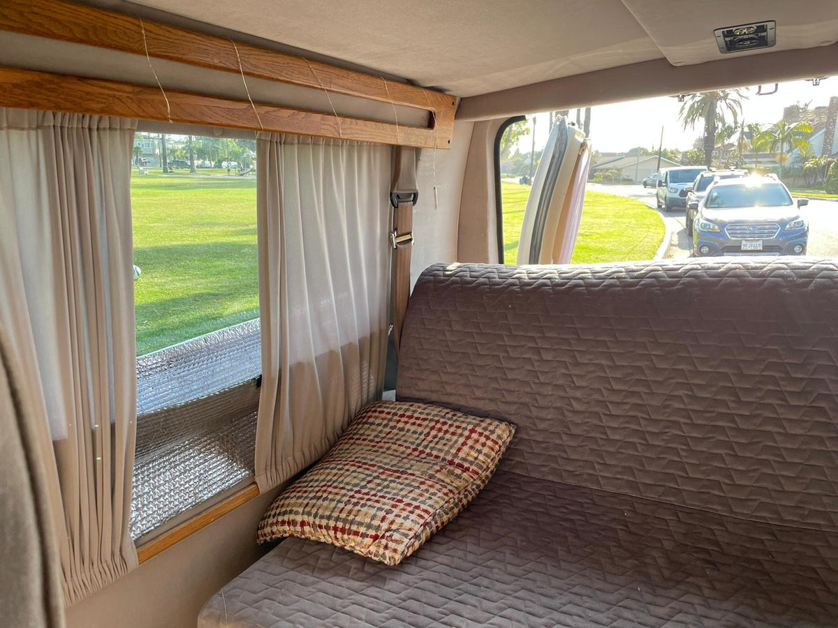 surrounded by camping gear on grass.|Inside an RV rental — photo 4