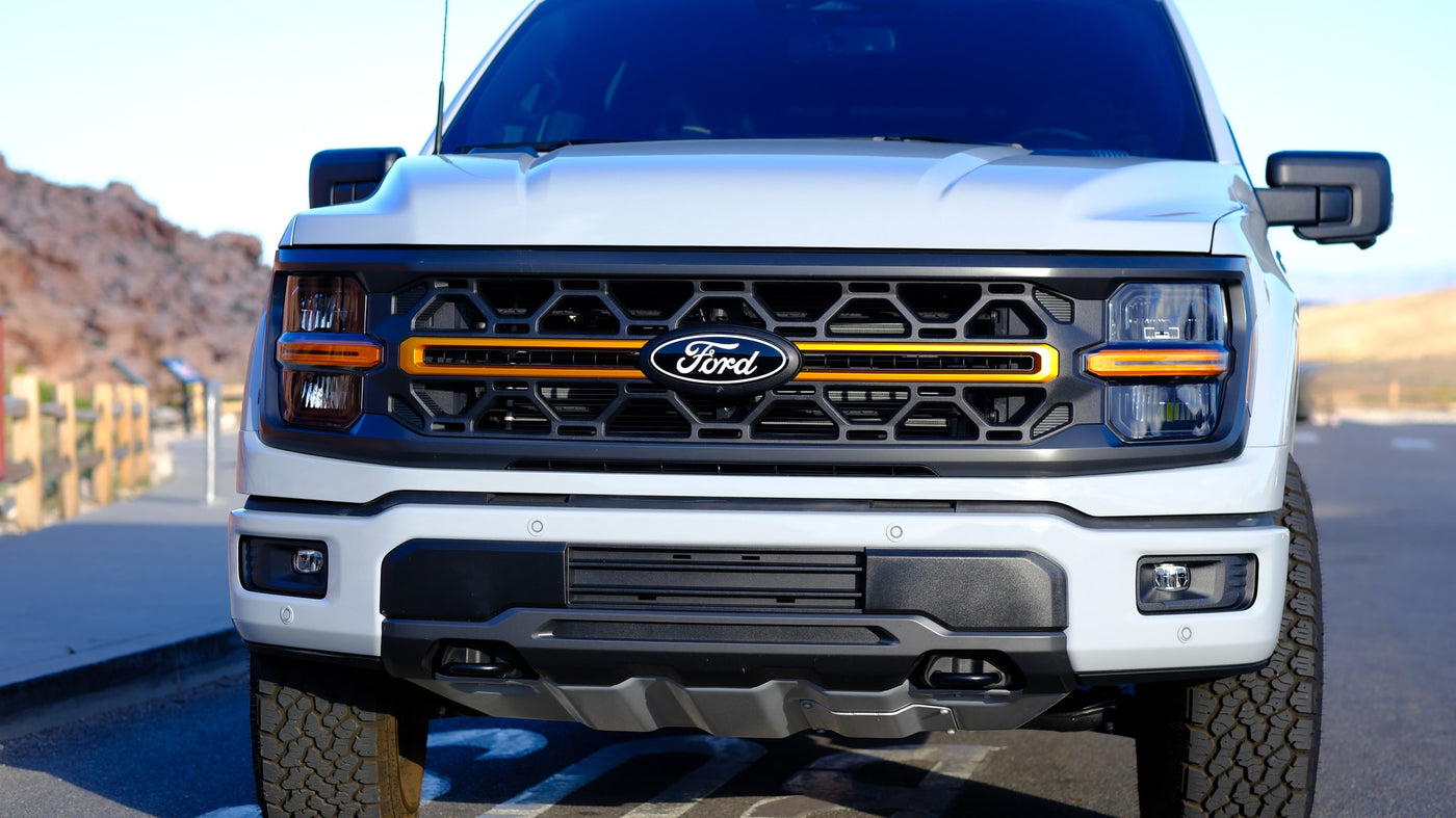 Front view of a white Ford F-150 with orange grille accents, ideal for adventure or an RV rental trip. — photo 11