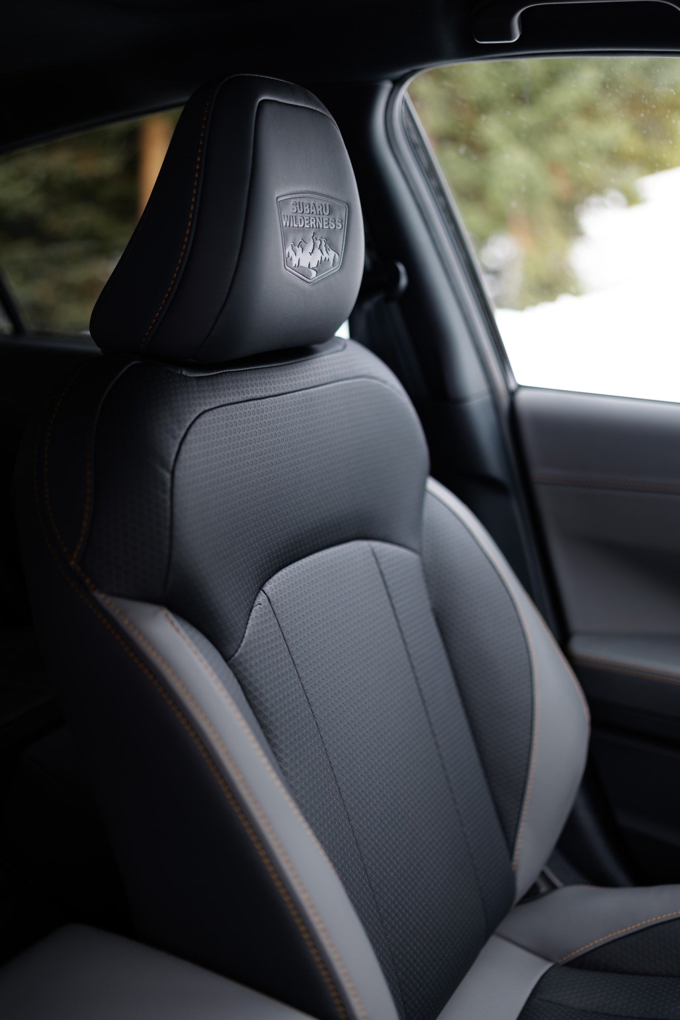 Subaru Wilderness car seat, detailed headrest logo & orange stitching. Premium interior comfort for your next RV rental adventure.