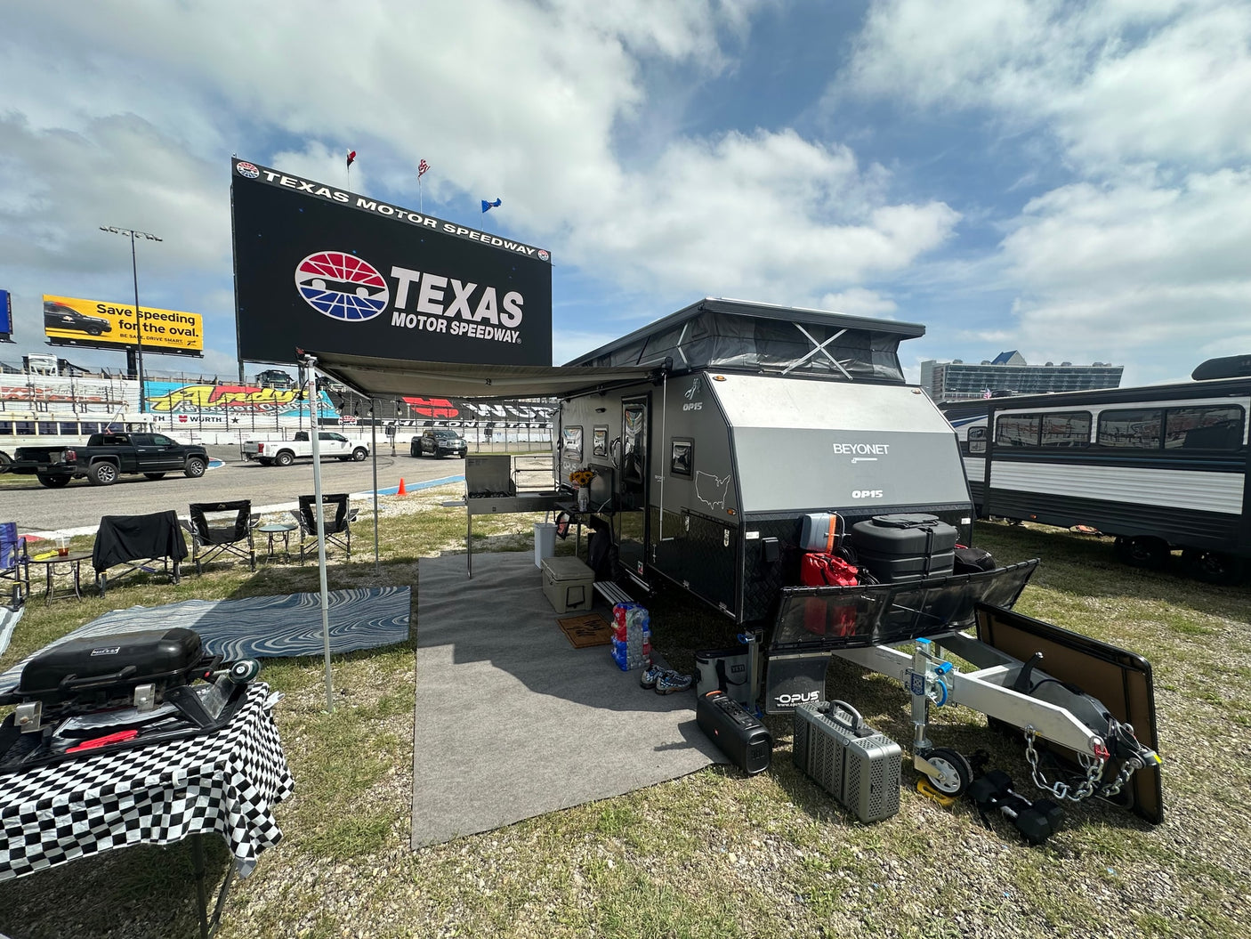 and comfortable seating.|Experience race day camping! This equipped off-road RV setup at Texas Motor Speedway is perfect for an RV rental adventure.|Cozy RV rental interior featuring a modern pop-up camper design with a bed