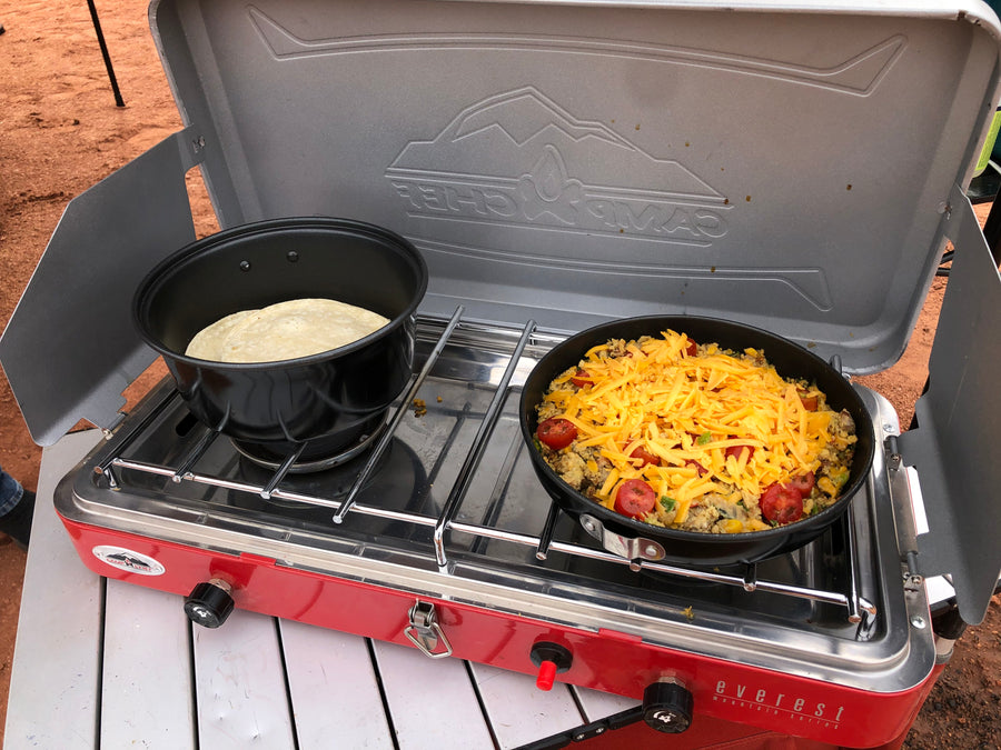 Delicious outdoor breakfast cooked on a Camp Chef camping stove with cheesy skillet and tortillas, ideal for your RV rental journey.