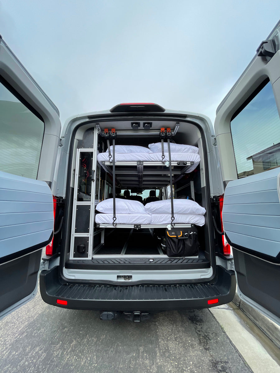 Rear view of a grey van converted for RV rental, featuring a custom interior with two stacked bunks & storage solutions.