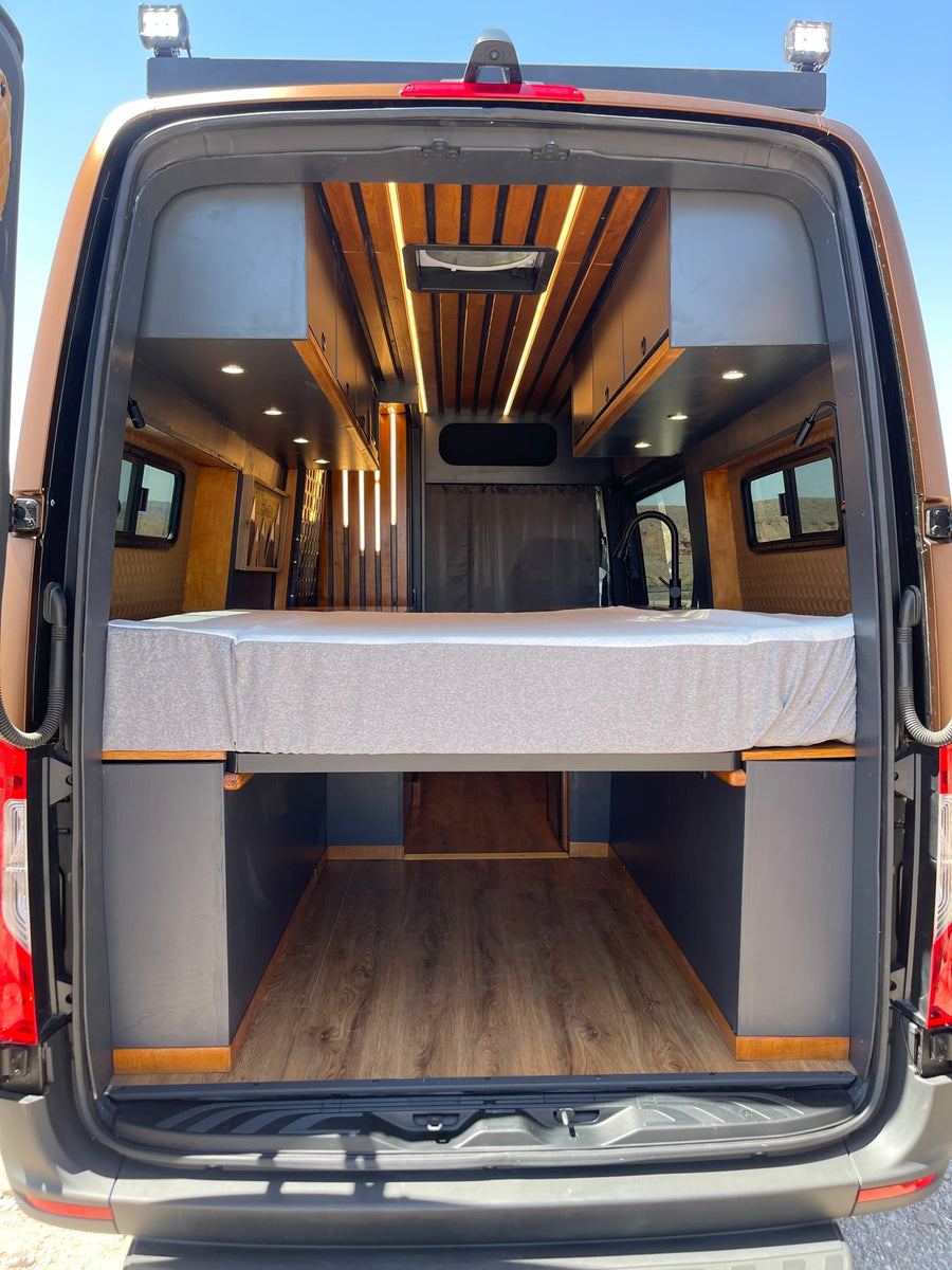 and includes a JBL speaker for cabin audio.|Explore this RV rental's cozy interior: a sleek kitchen area with sink