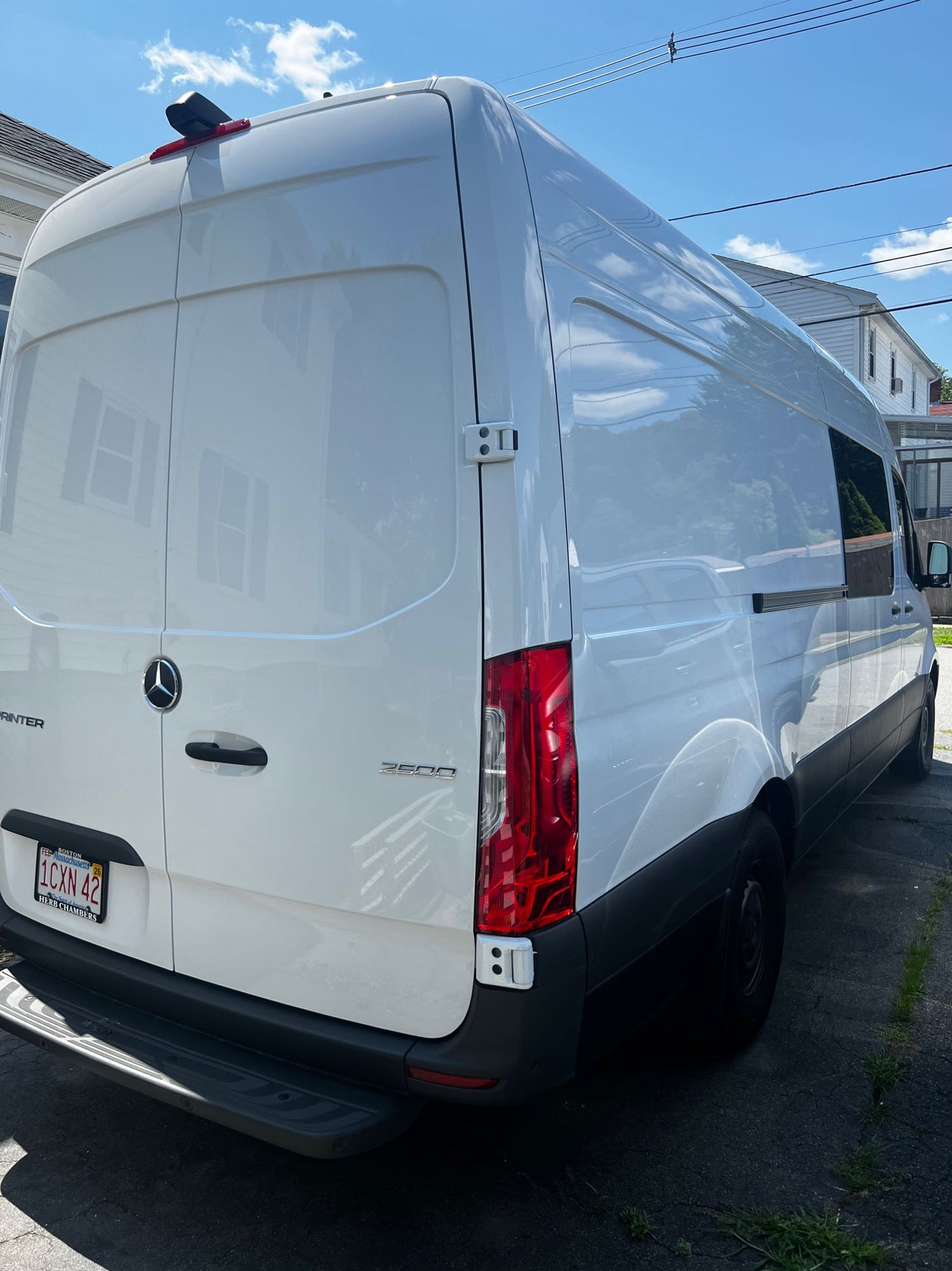 and open rear doors of a camper van.|Optimized RV rental interior: Wall-mounted remotes