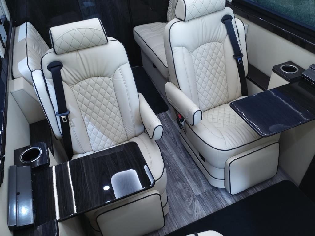 and touchscreen controls.|Experience comfort in this luxury RV rental interior. Plush cream captain's chairs