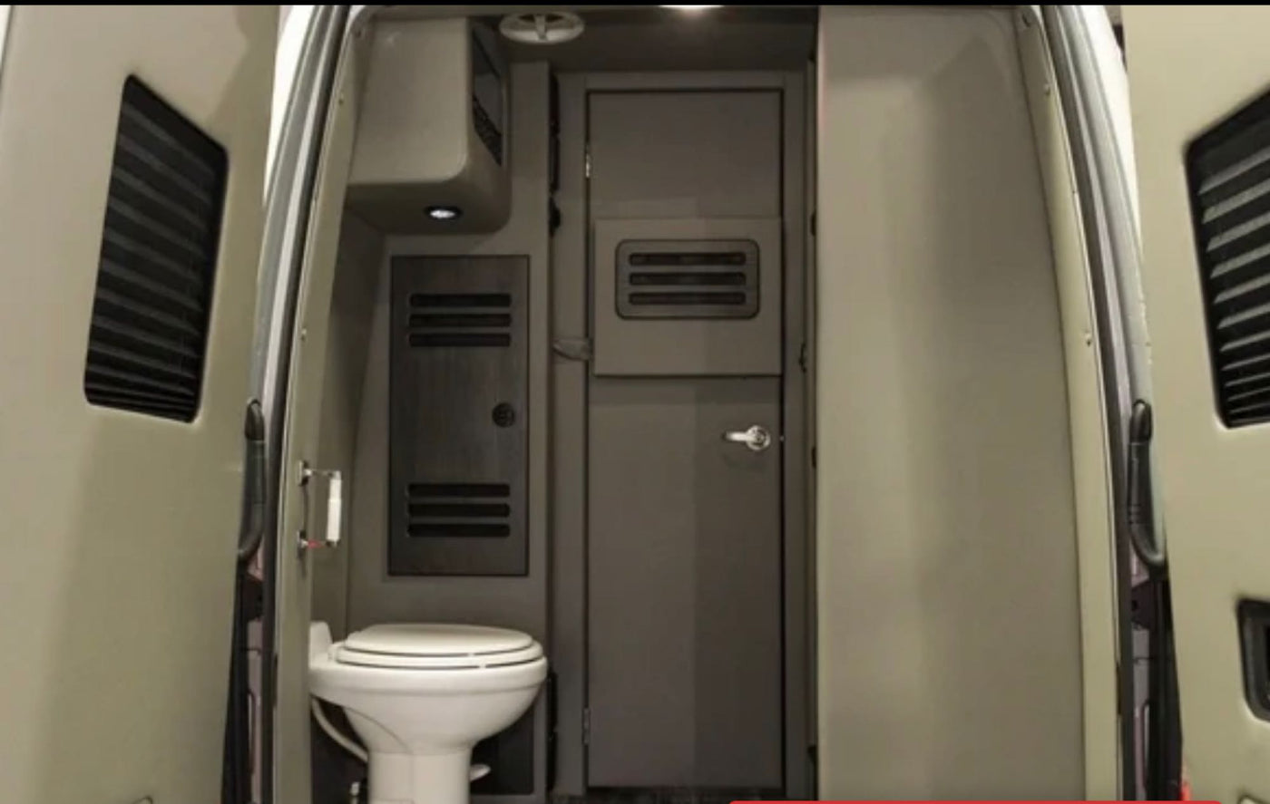 An RV rental's interior from the rear doors, featuring a compact toilet, closed internal door, and ventilation. Practical for travel. — photo 19