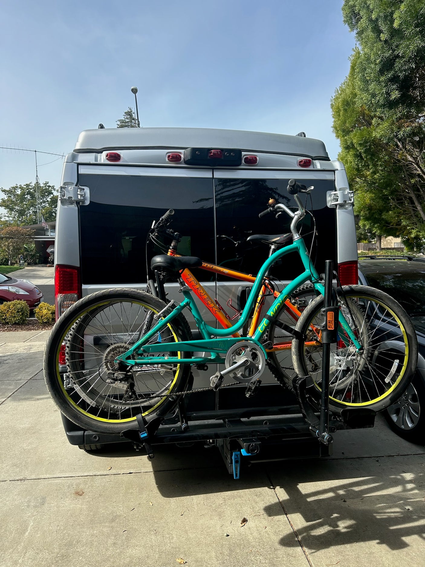 Rear view of an RV rental with two bikes secured on a hitch-mounted rack, ready for a cycling adventure.