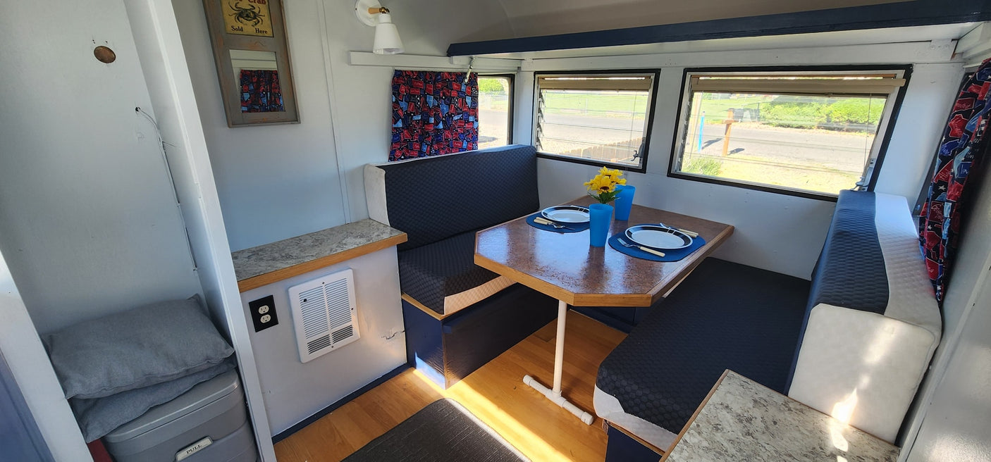 perfect for an RV rental adventure.|Bright RV rental interior featuring a dinette with blue and white seating