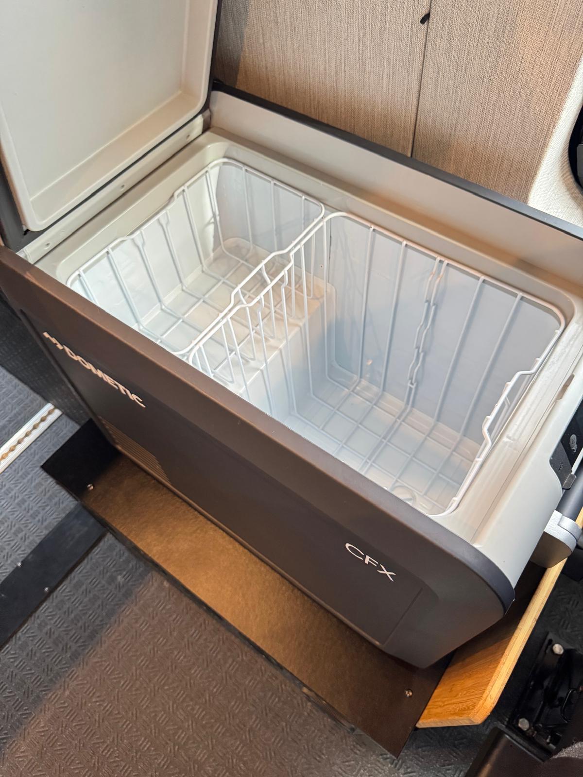 Open Dometic CFX portable fridge/cooler for rv rental. Two wire baskets inside for organized camping storage.