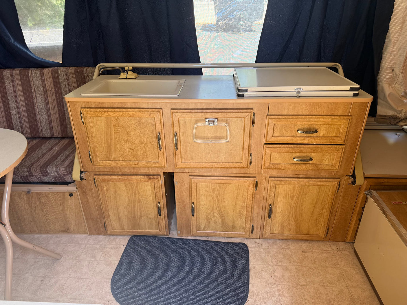 ready for an outdoor adventure among green trees.|RV rental pop-up camper kitchen: sink