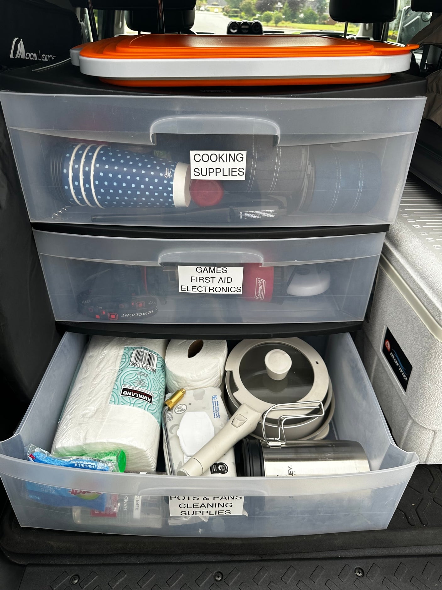Efficient RV rental organization: clear drawers hold cooking, first aid, electronics, and cleaning supplies for travel.