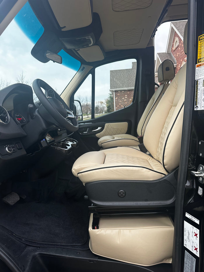 Luxury RV rental interior featuring premium cream seats and a well-appointed driver's area for comfortable travel.