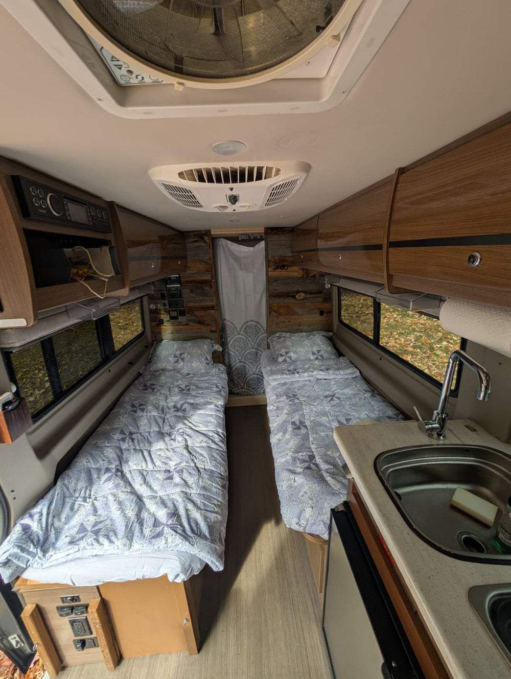 parked on a quiet residential street in soft evening light.|Explore this RV rental! Rustic wood interior