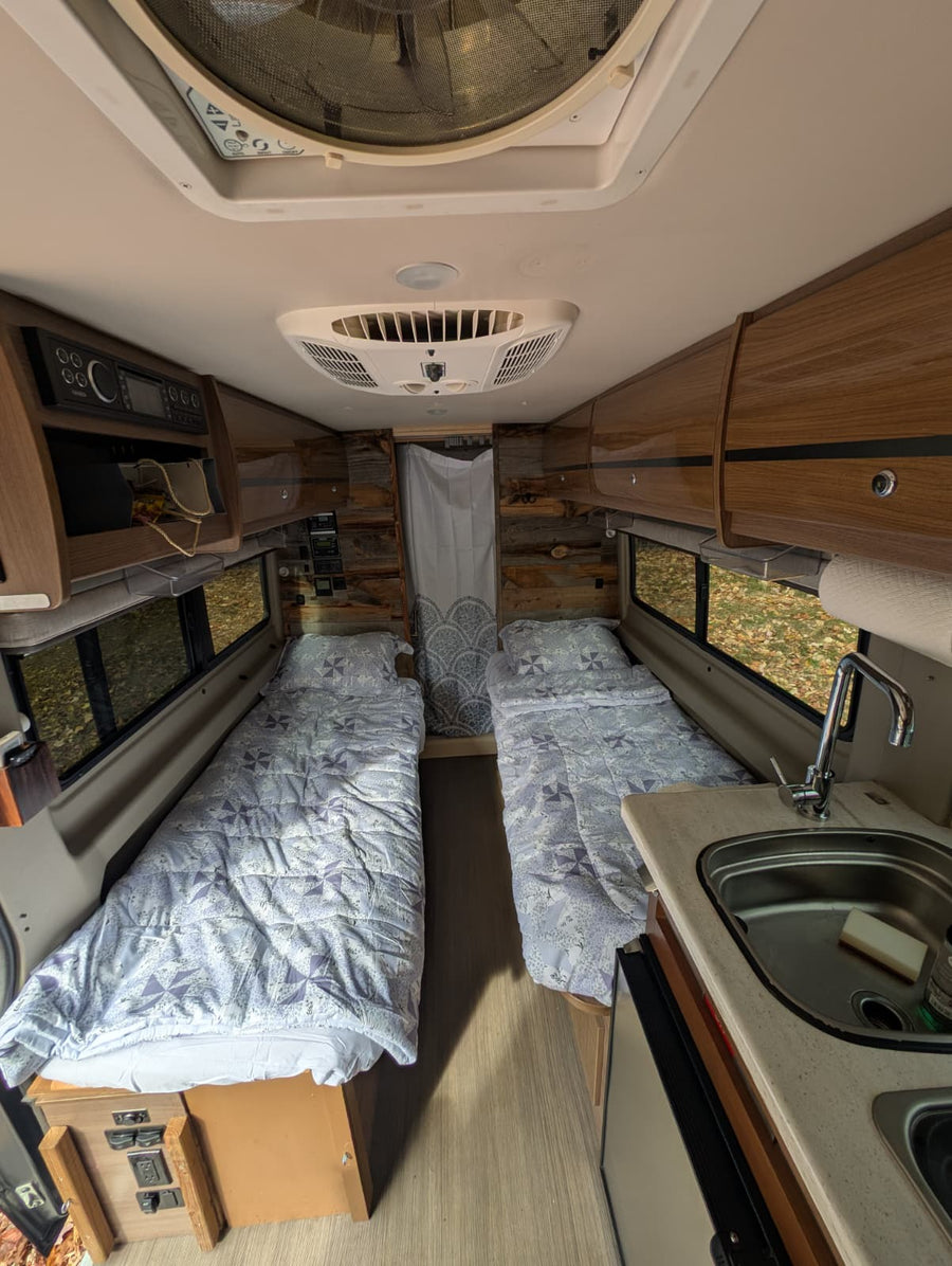 parked on a quiet residential street in soft evening light.|Explore this RV rental! Rustic wood interior