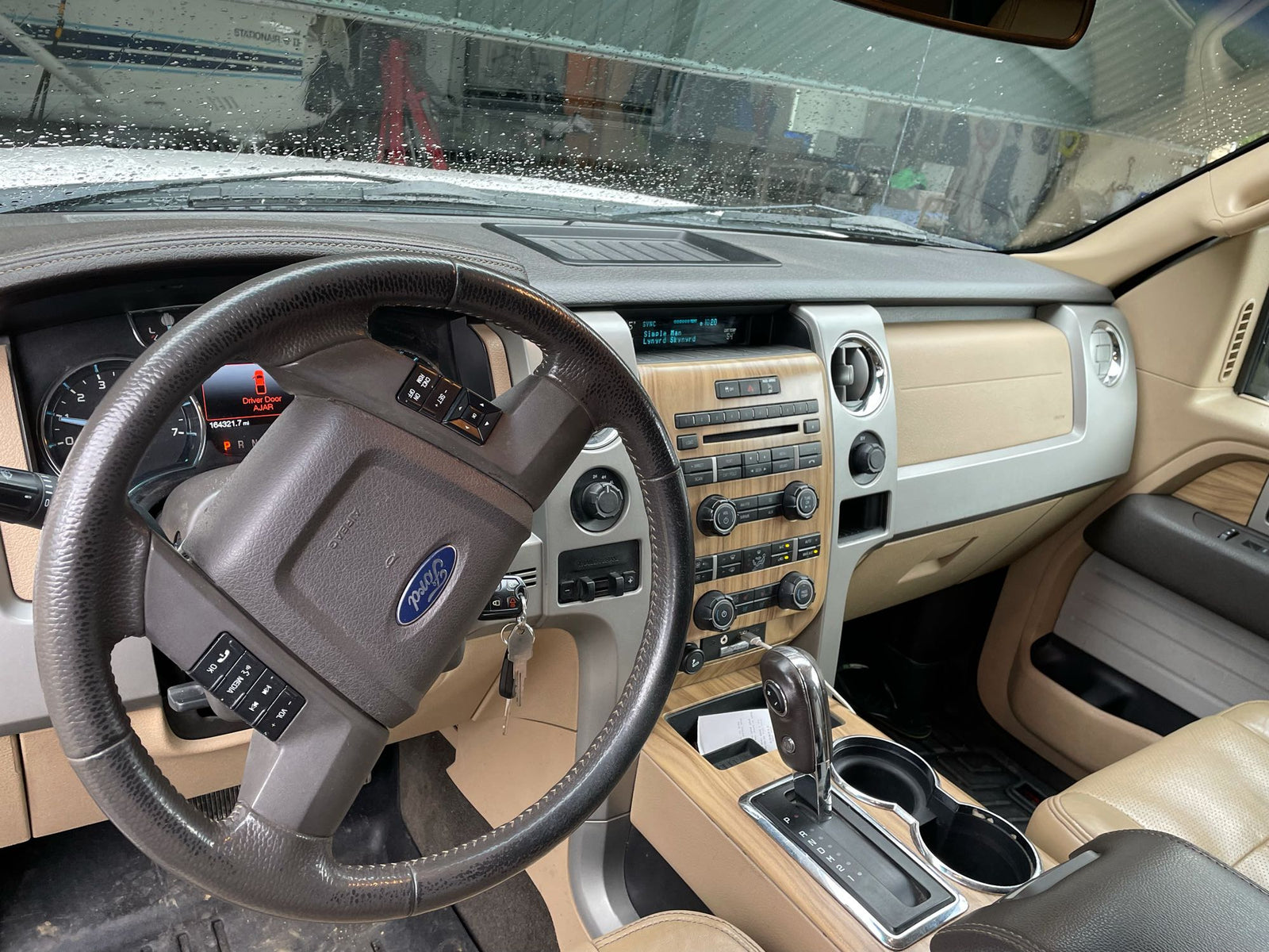 beside an RV rental. A small plane is in the hangar.|A white Ford F-150 pickup truck