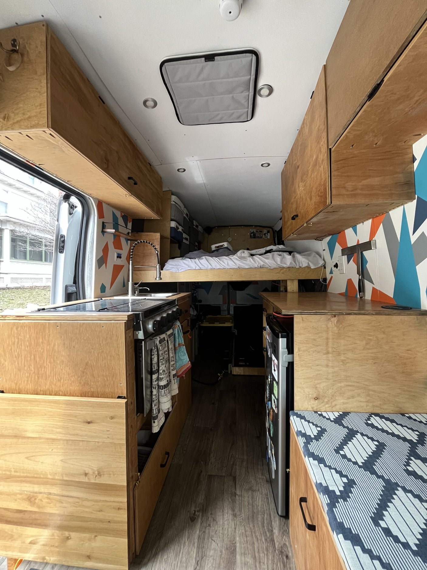 and cozy interior for travel.|Stylish RV rental interior: wooden kitchenette with fridge