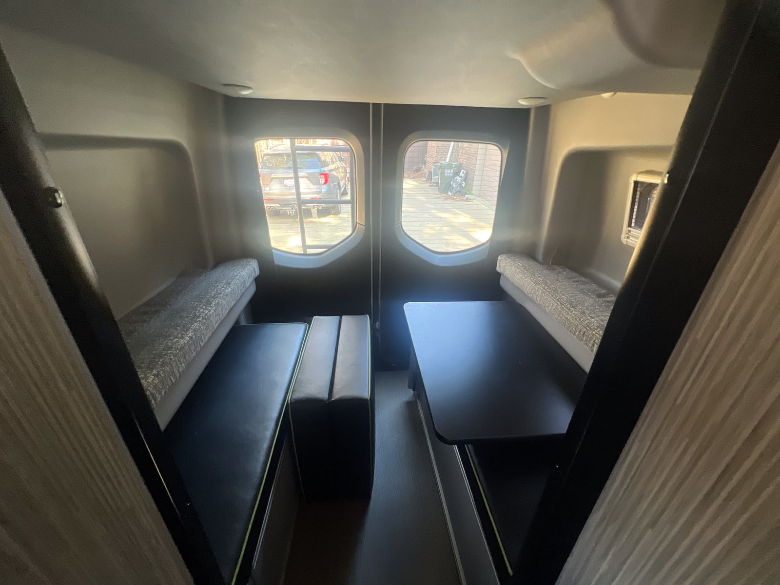 ideal for your next RV rental. Parked on a sunny concrete driveway.|Spacious RV rental interior with dinette seating & tables