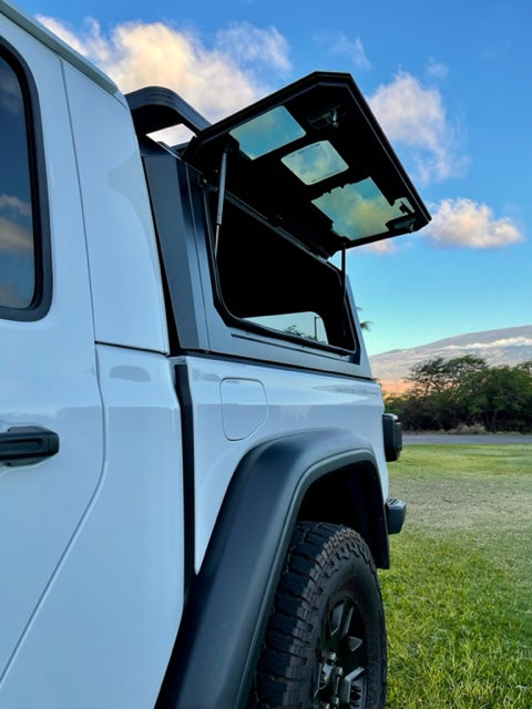 White Jeep Gladiator RV rental with open camper shell, ready for outdoor adventures.