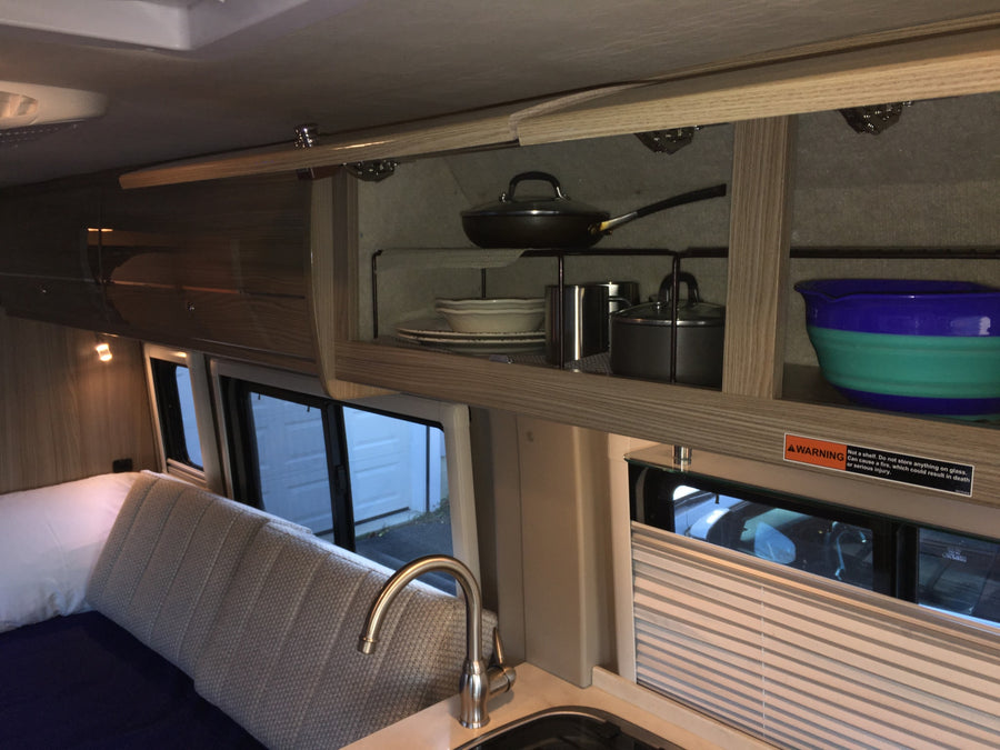 parked by a white gazebo.|This dark gray camper van