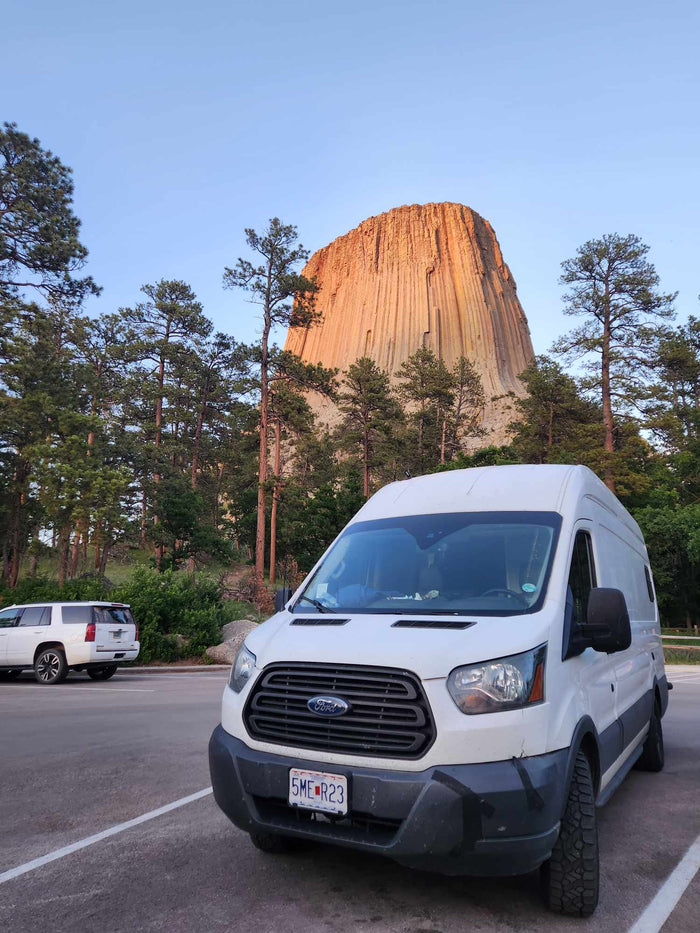 starry sky & dark rocky terrain.|This RV rental showcases a thoughtfully designed camper van interior with a cozy bed