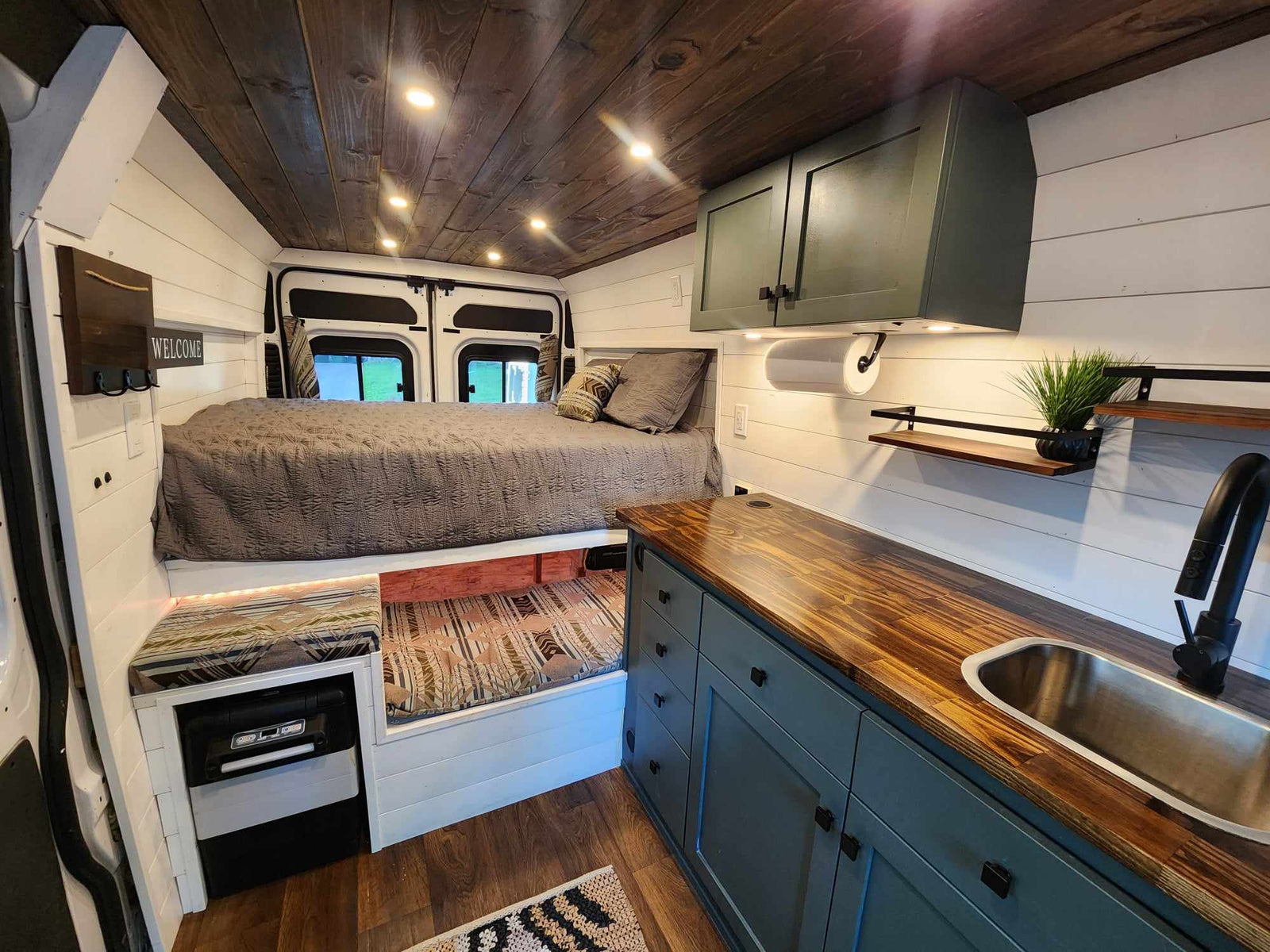 Inside a cozy RV rental: custom van conversion with raised bed