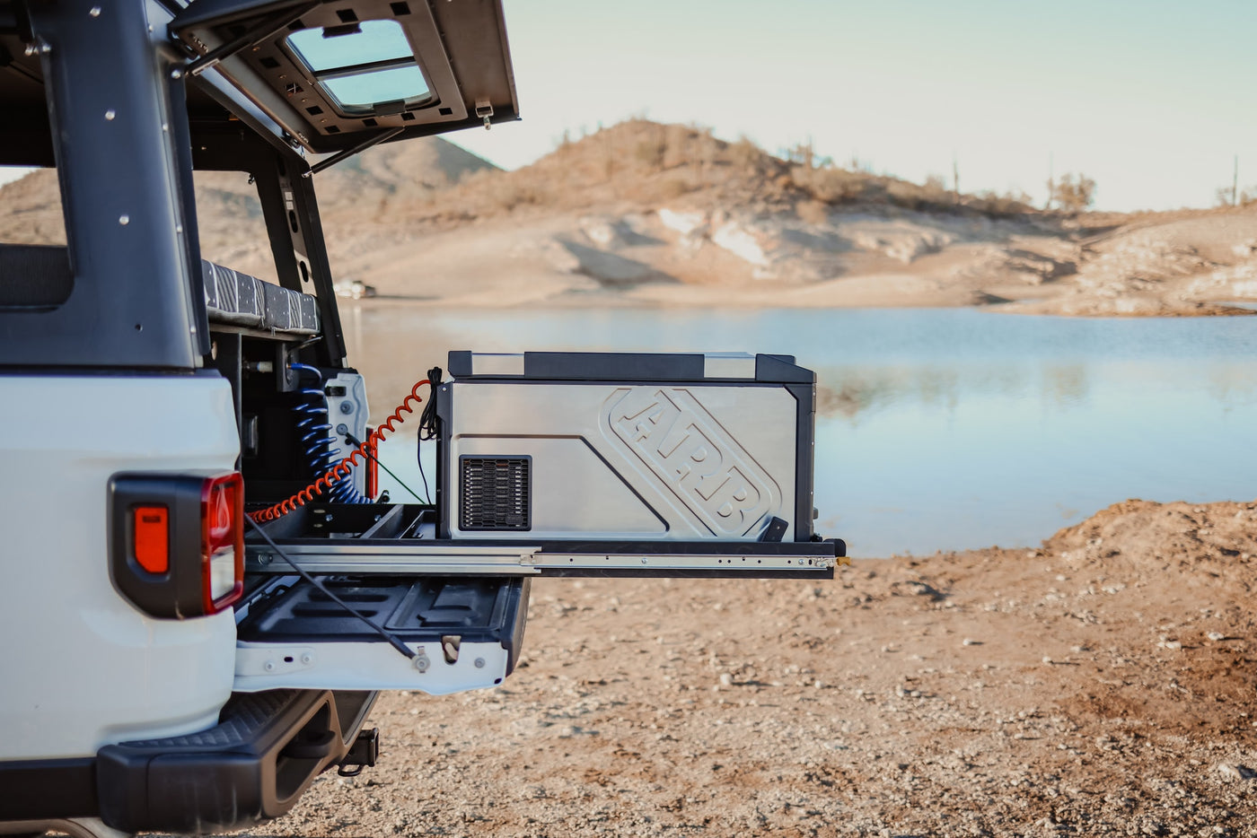 Overland RV rental setup: Jeep Gladiator with ARB fridge extended at a desert lake campsite, perfect for remote adventures. — photo 11
