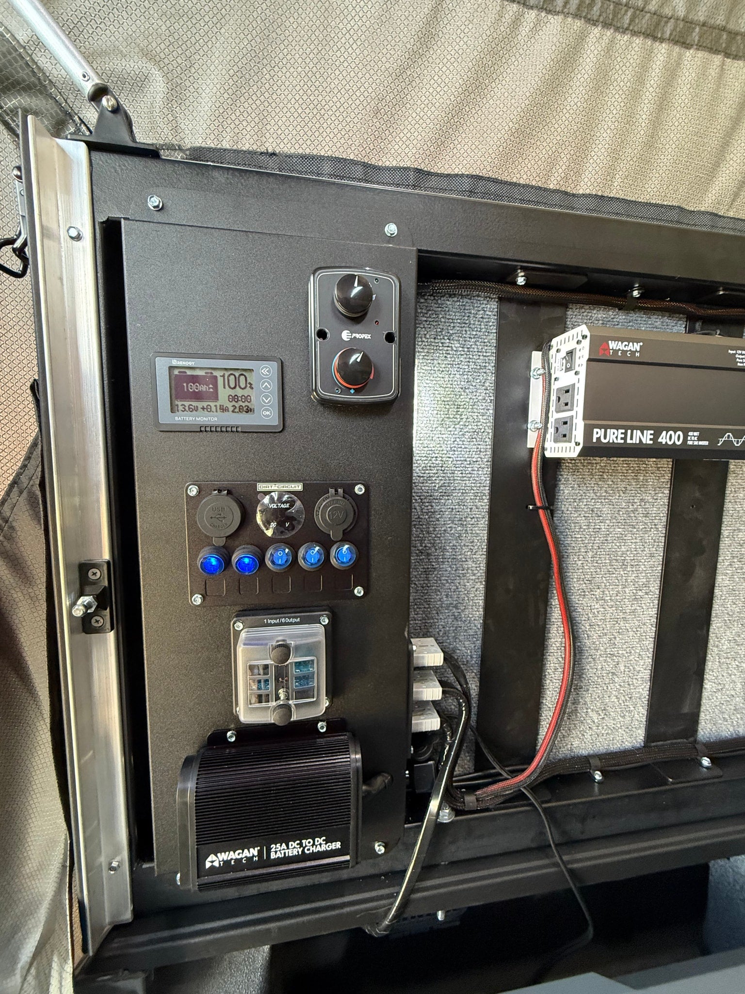 RV rental's integrated electrical panel, showing battery monitor, inverter, and charger for essential mobile power.