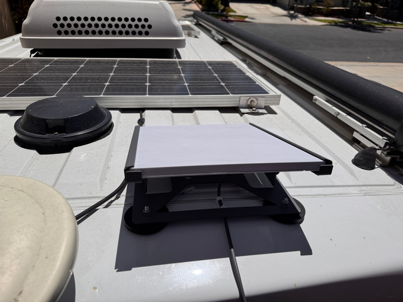 RV rental: Rooftop view of a solar panel, Starlink dish, and vent. Essential gear for mobile connectivity and adventures.