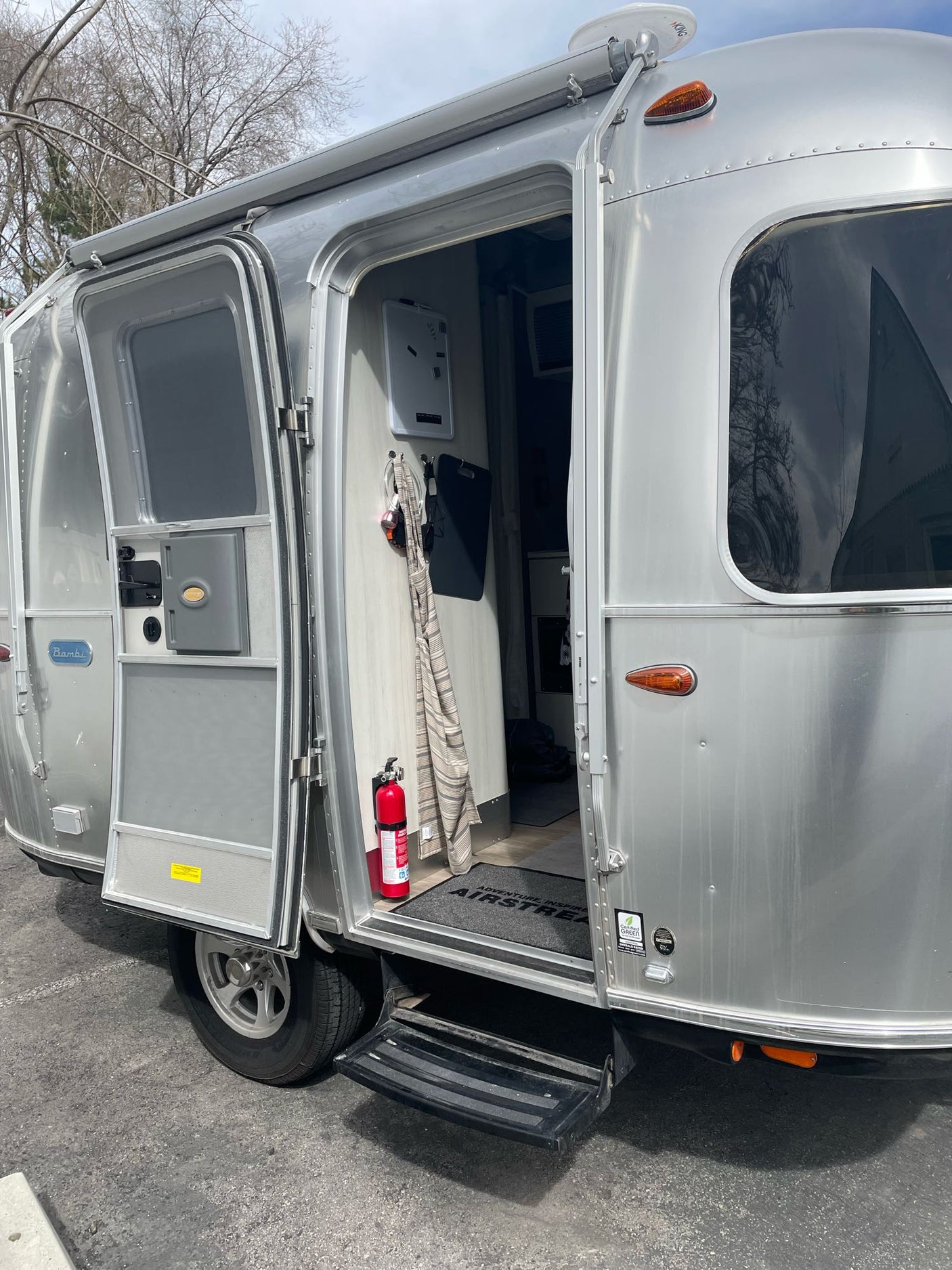 This silver Airstream Bambi RV rental has its door open, revealing the cozy interior, ready for adventure.