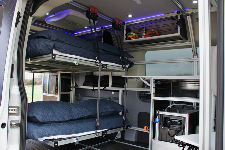 Modular RV rental interior featuring suspended bunk beds, smart storage, and integrated power for travel comfort.
