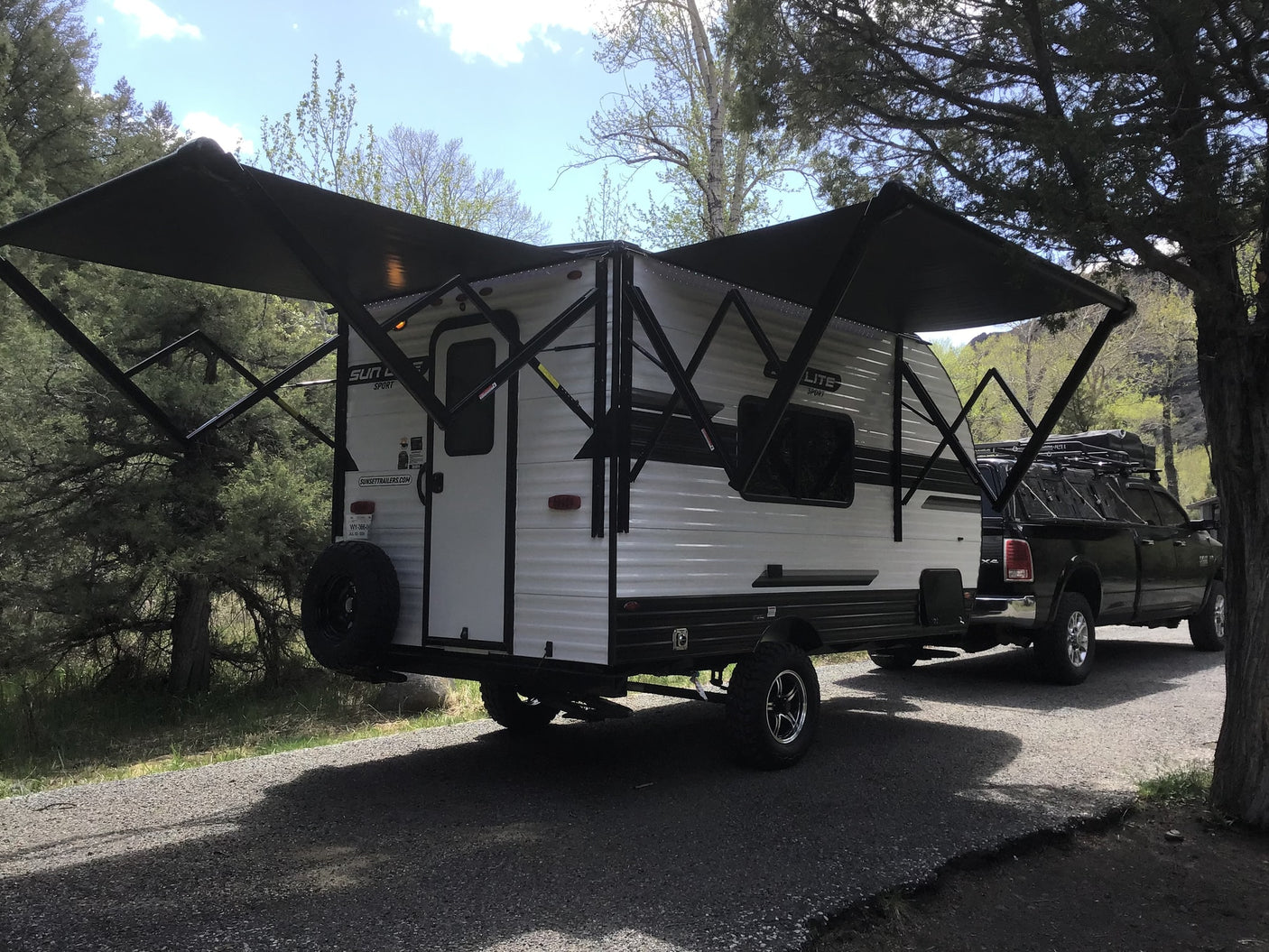 RV rental travel trailer & pickup truck under an extended awning