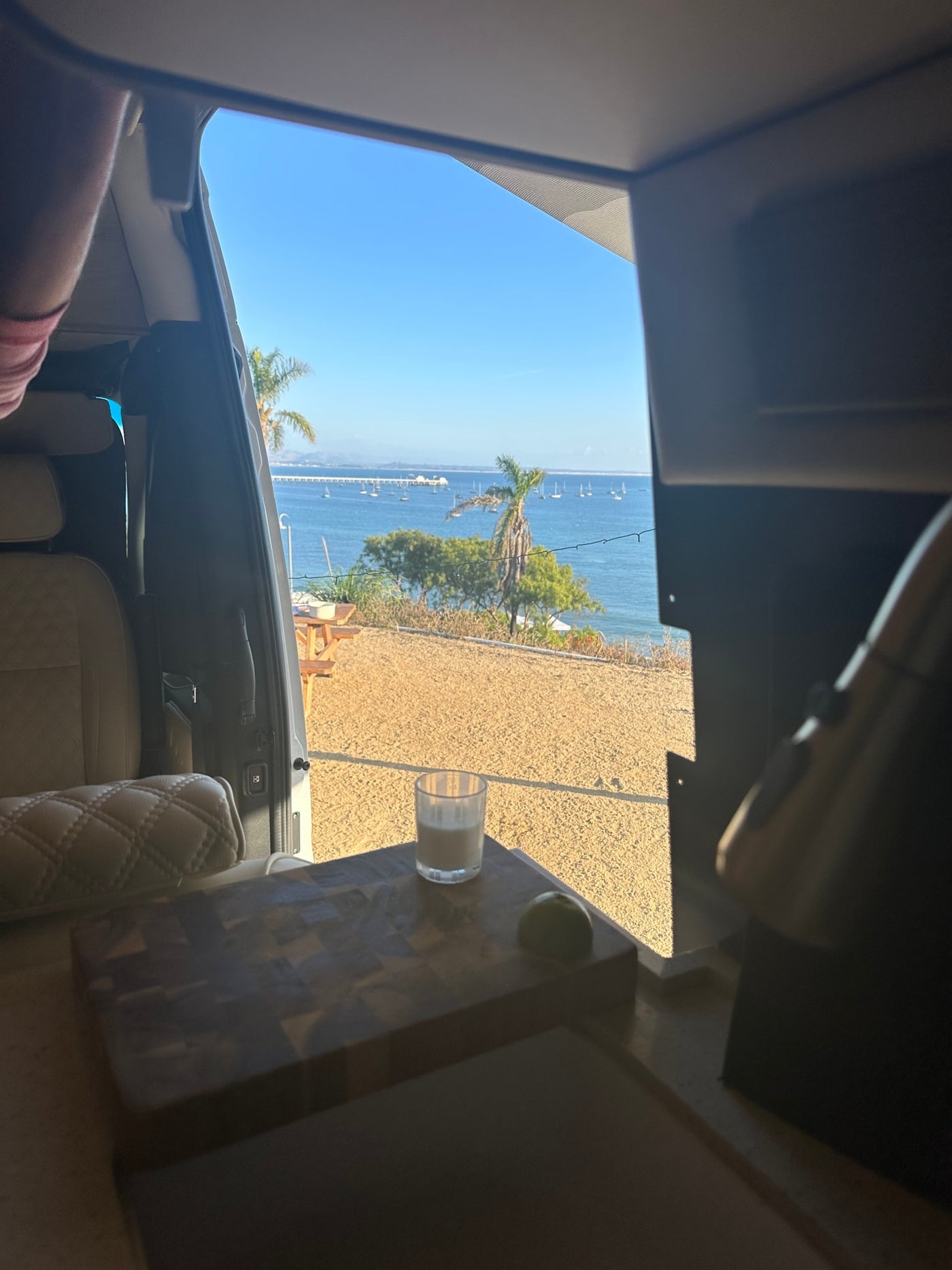 RV rental morning view: tranquil ocean, sailboats, and a refreshing drink with lime on a cutting board. Relaxing travel. — photo 17