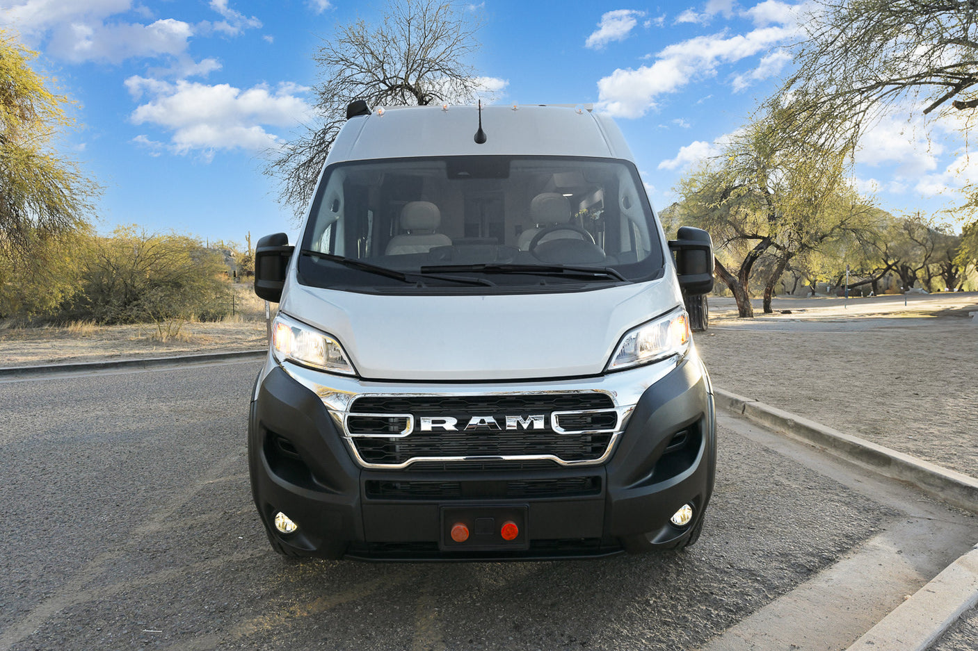 Front view of a white Ram ProMaster RV rental van, ideal for road trips, camping, and desert adventures.
