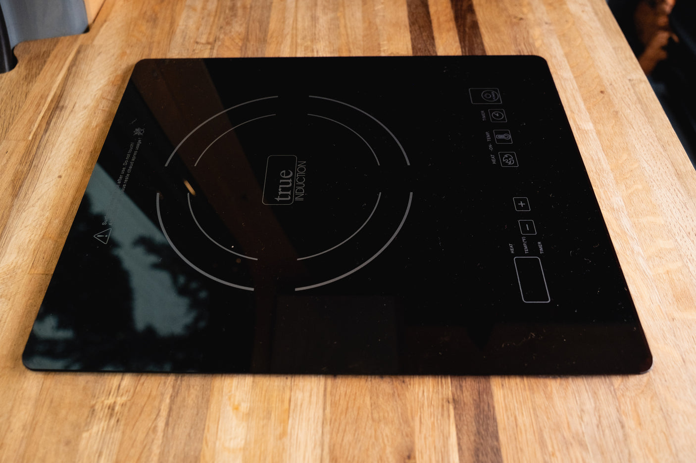 This True Induction cooktop on a wooden counter is perfect for an RV rental kitchen, ideal for compact cooking.