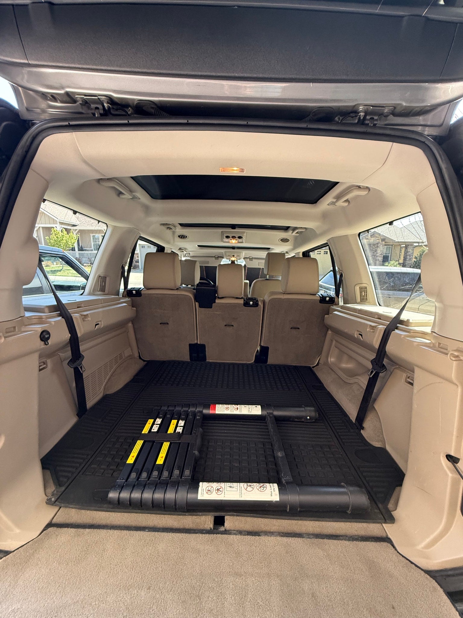 Roomy SUV cargo area, suitable for an RV rental road trip. Features beige interior, rubber mat, and rear passenger seats.