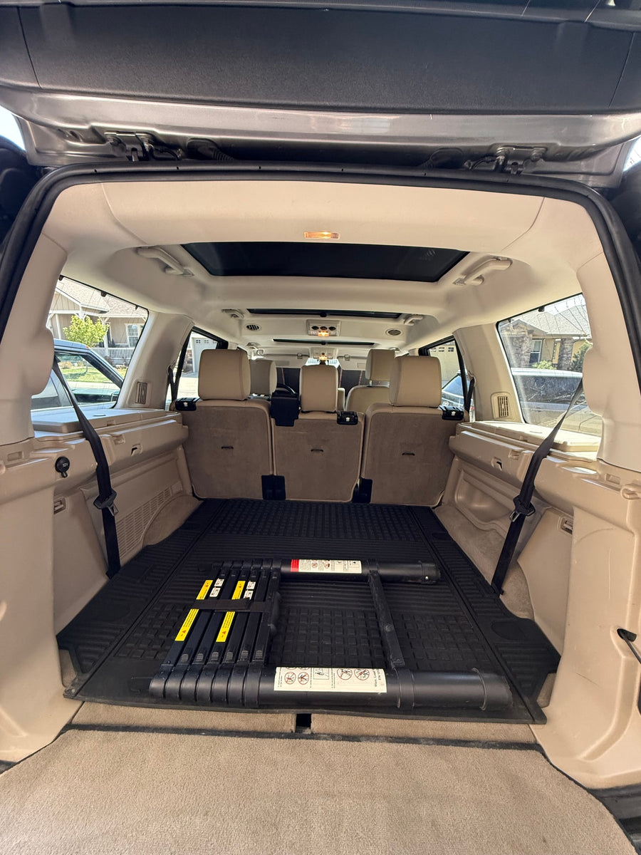 Roomy SUV cargo area, suitable for an RV rental road trip. Features beige interior, rubber mat, and rear passenger seats.