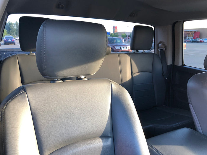 and bright parking lot visible through windshield.|Pickup truck in a shopping center parking lot at dusk
