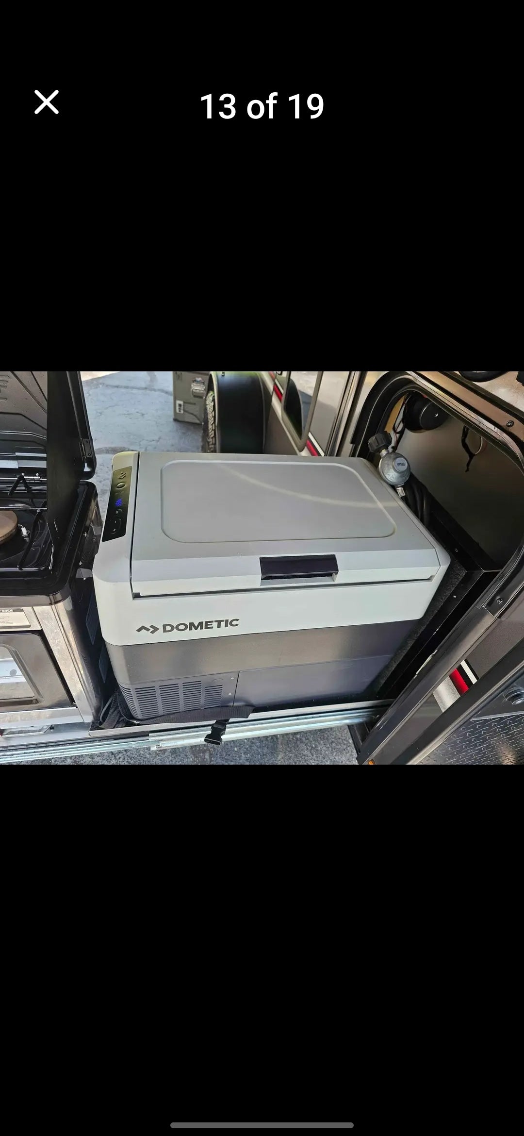 An RV rental's slide-out outdoor kitchen with a Dometic portable fridge/freezer and stove, ready for camping adventures.