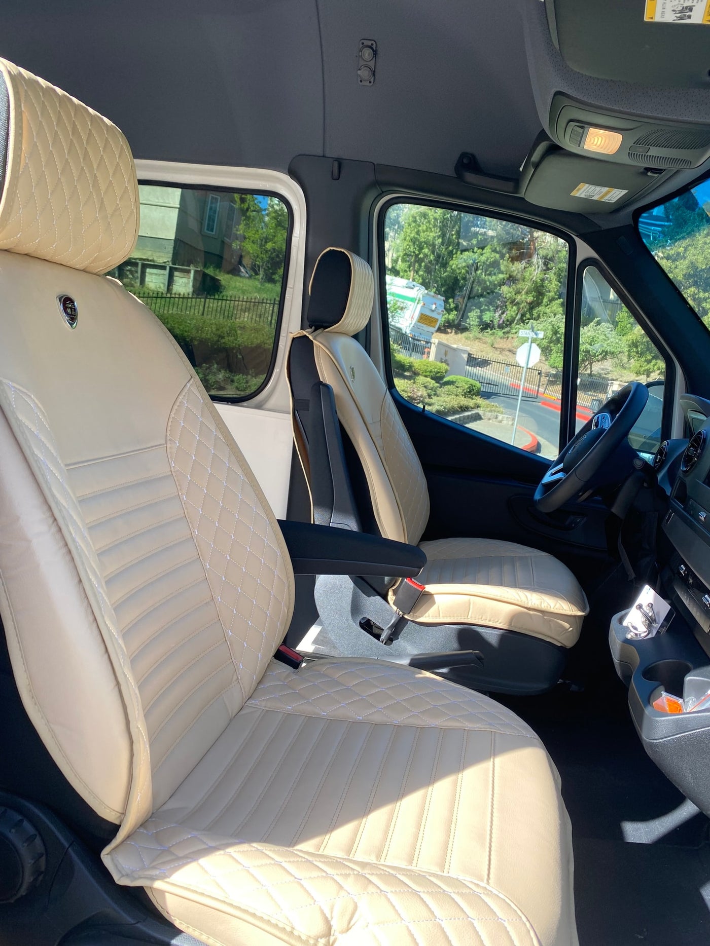 Inside this RV rental: plush, custom cream quilted front seats, offering comfort for your journey. — photo 3