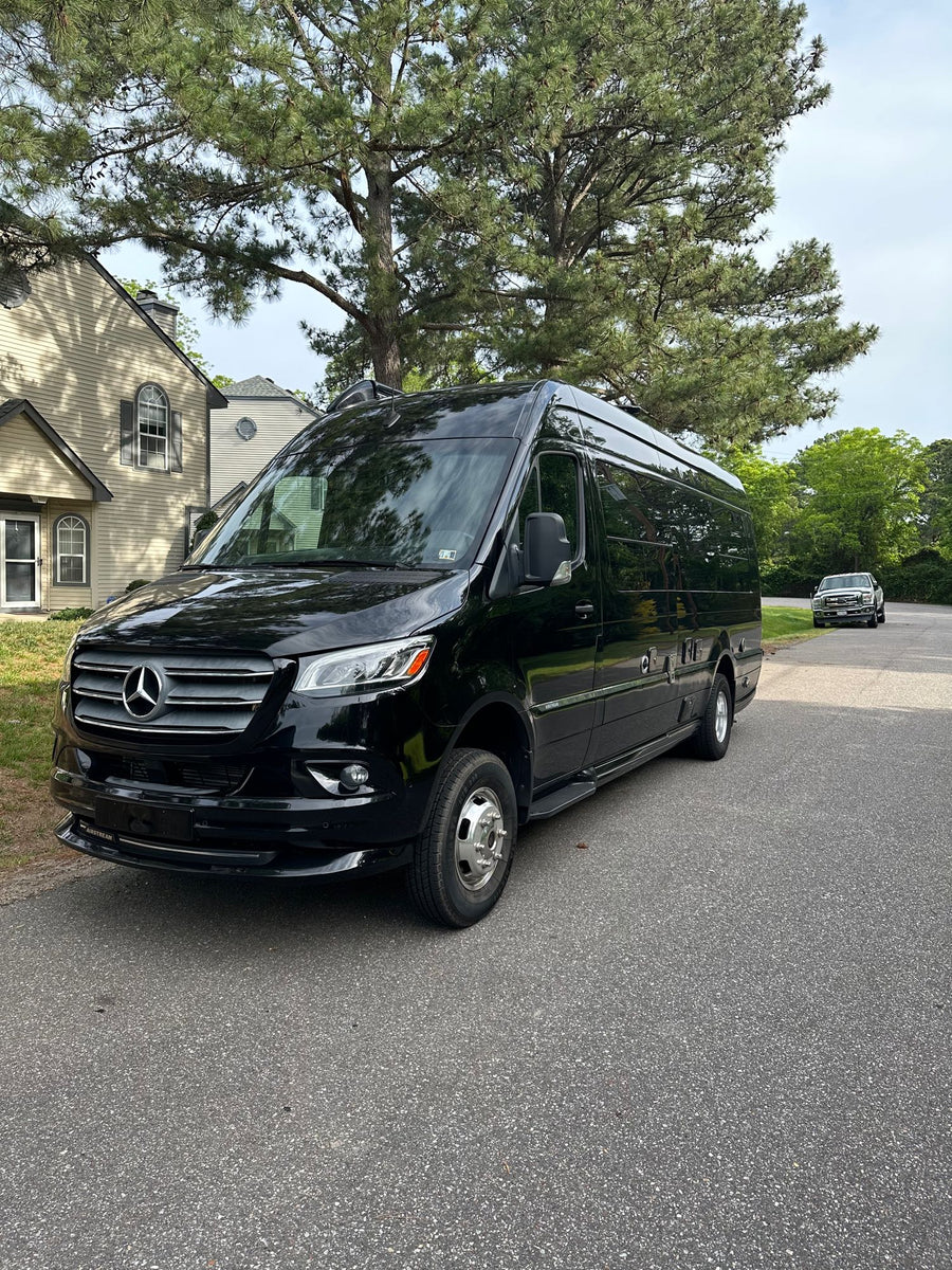 Black Airstream Mercedes-Benz Sprinter RV rental van parked on a sunny residential street