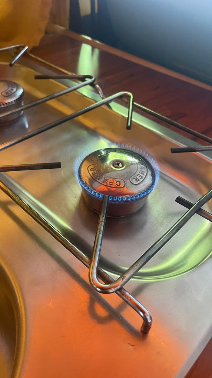 with a USB/DC outlet below.|RV rental's illuminated charging port features QC 3.0 USB-A and dual PD USB-C ports.|Interior of a vintage RV rental camper van with kitchenette