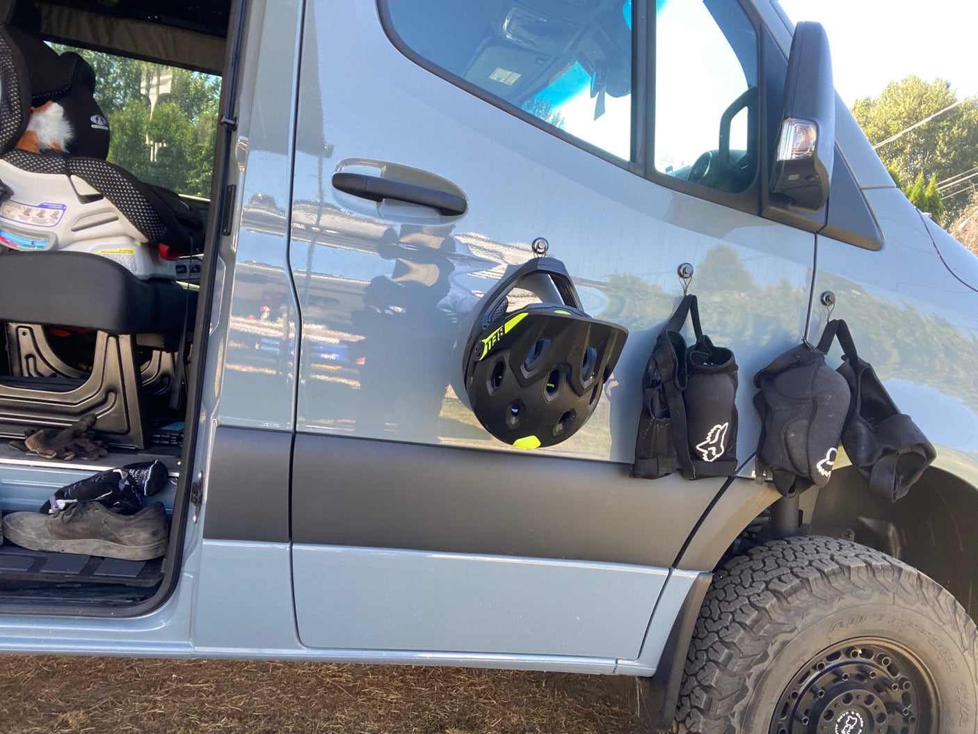 RV rental van displaying a bike helmet & protective pads on magnetic hooks, ready for outdoor adventure.