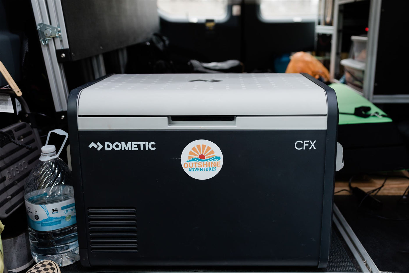 a comfy bed with patterned linens holds pillows reading 'SHINE ON' and 'Life is a beautiful ride.'|Cozy and functional camper van bed setup