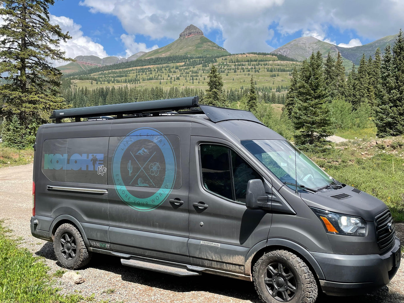 parked on a dirt road with majestic mountains & green forests under a cloudy sky.|Cozy bunk beds in an RV rental — photo 2