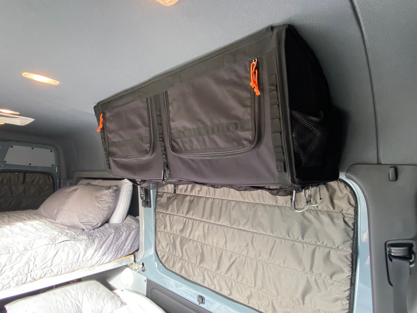 Inside an RV rental: versatile overhead storage, a cozy bed, and practical window coverings optimize comfort on the road. — photo 18