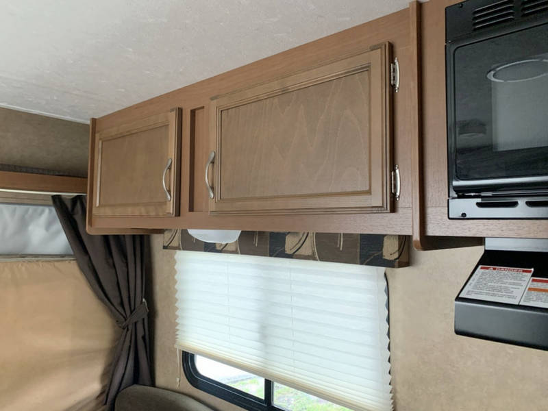 ideal for RV rental.|RV rental kitchen appliances: a black microwave oven installed over a range hood — photo 3