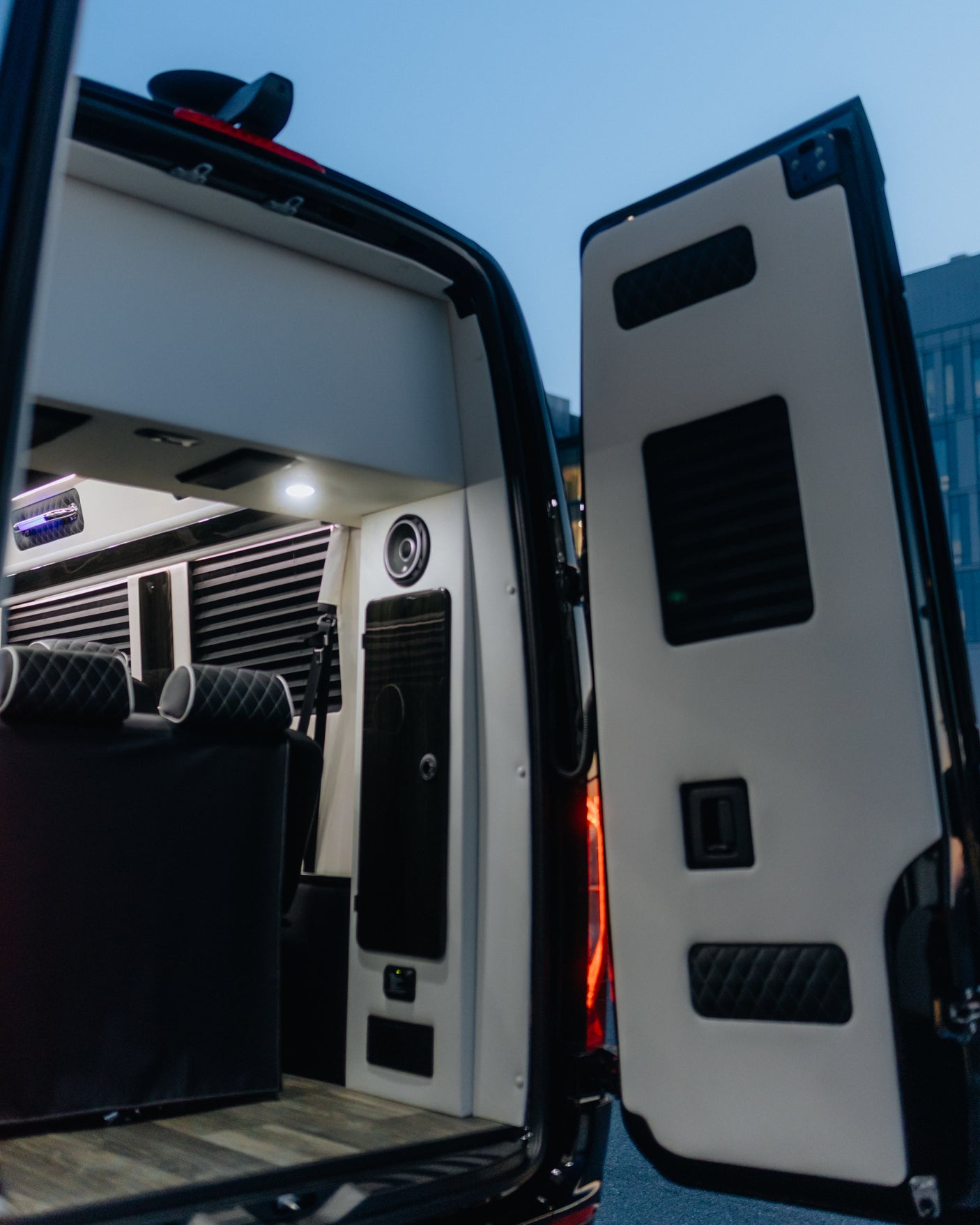 Luxury RV rental interior: Custom van with plush seating, wood flooring, and modern lighting. Perfect for comfortable travel.
