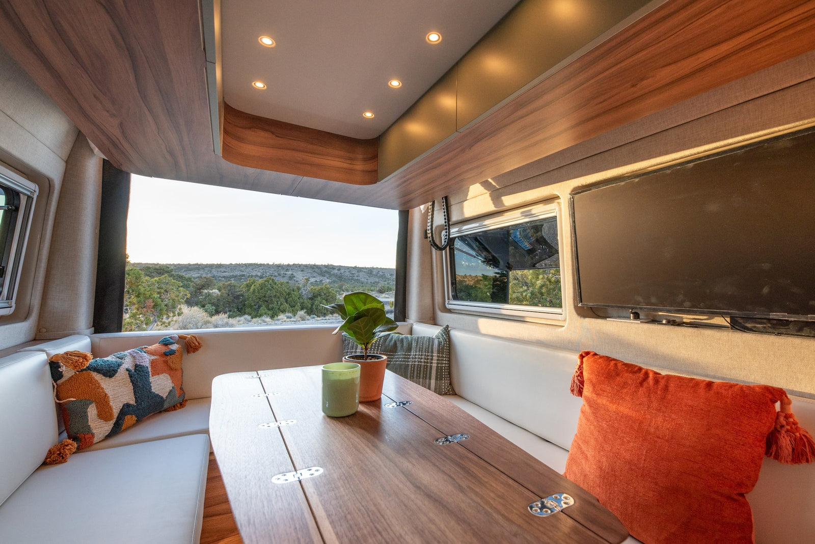 Experience comfort in this rv rental. Dining area with a foldable table, cozy benches, and a stunning view.
