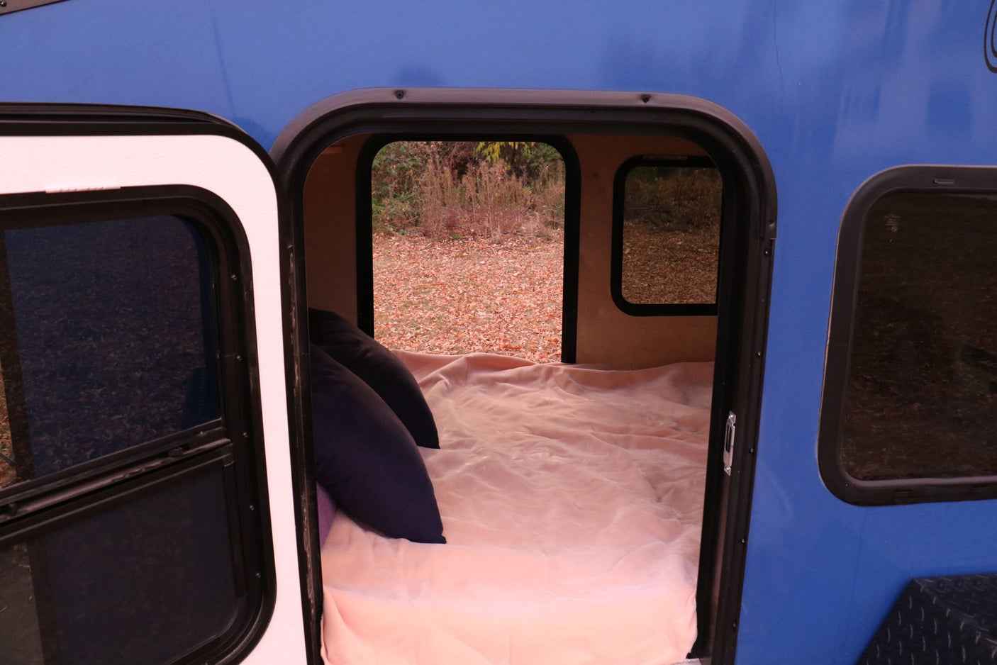 ready for your camping trip.|Cozy RV rental interior: a bed with pink blanket